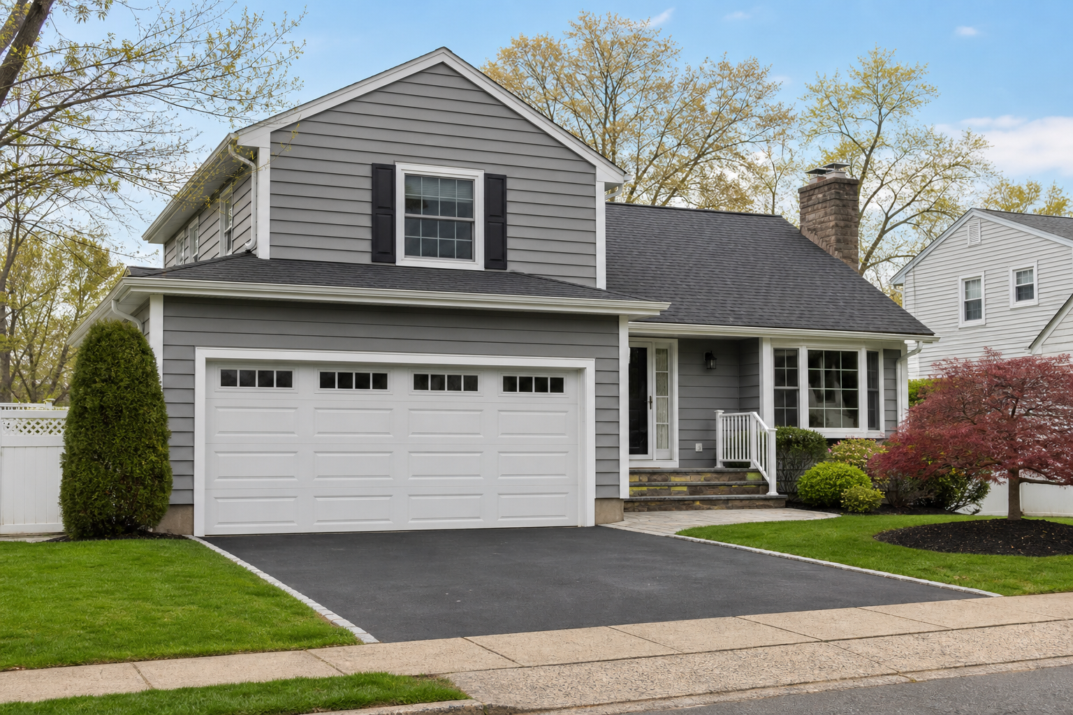 Suburban Cranford home with a visible garage door in a clean driveway setting
